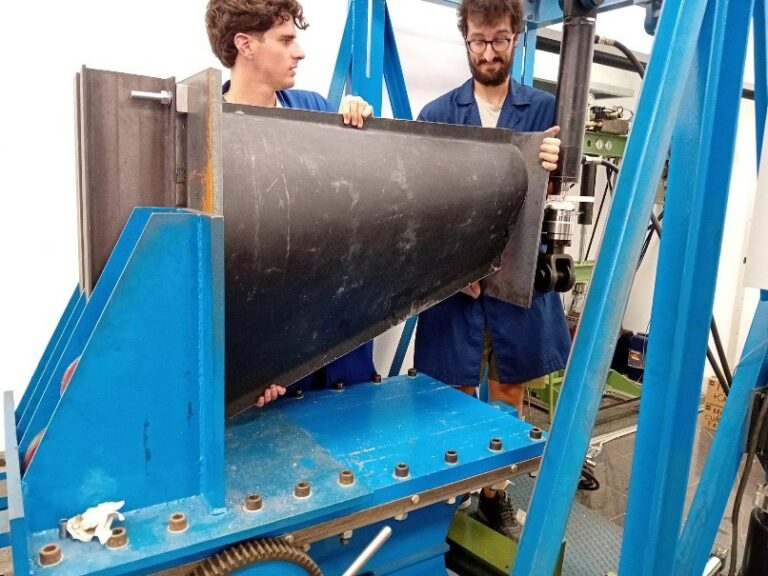 Investigadores preparando una sección de pala eólica para un ensayo de flexión
